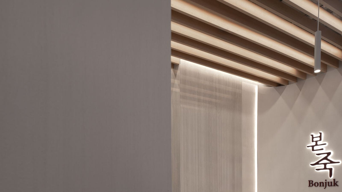 Bonjuk interior detail with slatted wood ceiling and logo