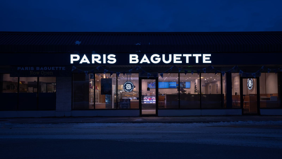 Paris Baguette storefront exterior at night with illuminated signage
